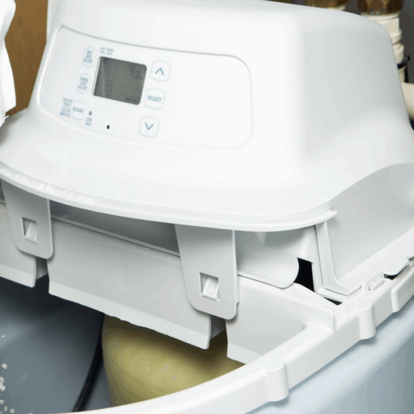 Remplissage d’un adoucisseur d’eau avec du sel régénérant en granulés.